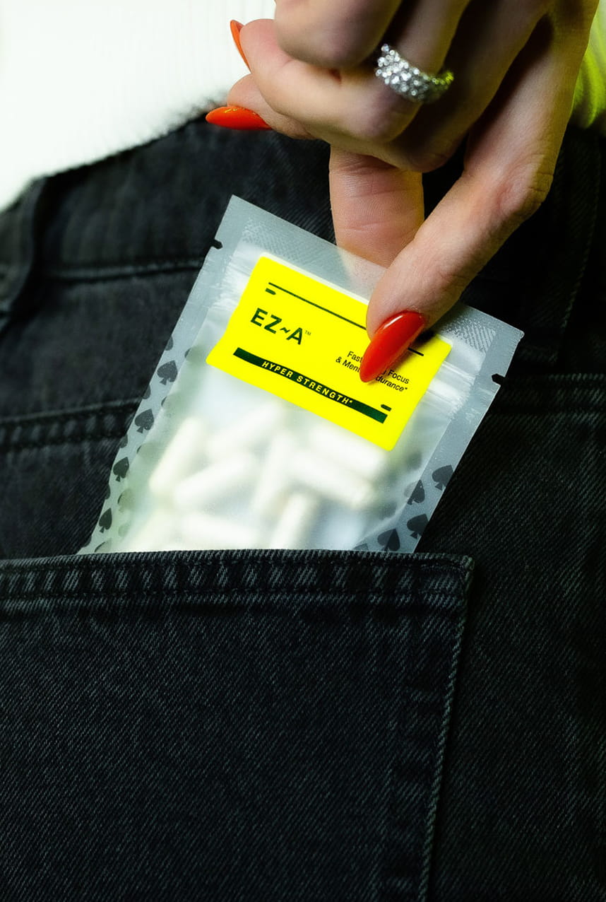 Hand holding a package of EZ-A band-aids against a black denim background
